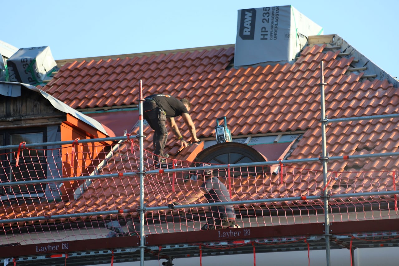 A roofer laying tile on a finished roof