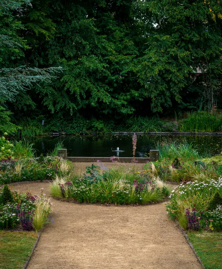 A garden path leading to a tranquil pond