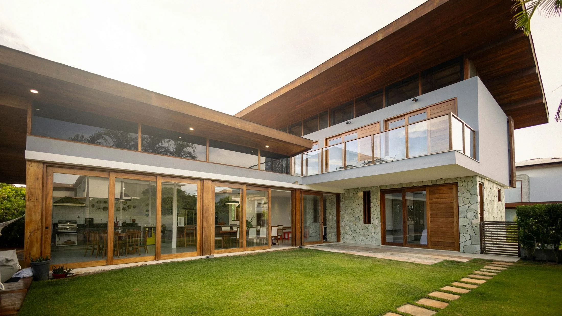 A warm modern home with a strong horizontal roofline and green lawn